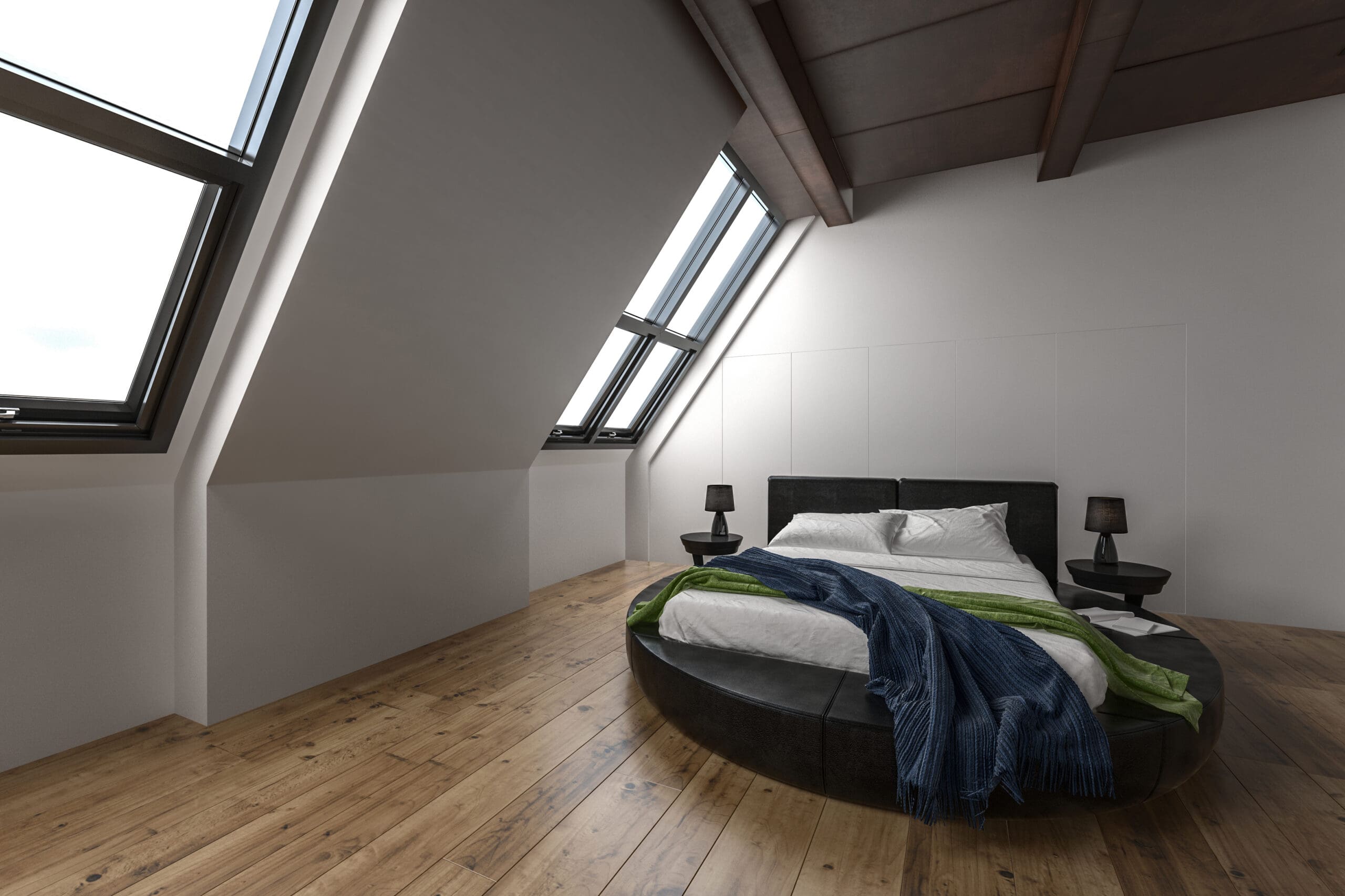 A modern bedroom with a round bed, white bedding, and blue and green throws. The slanted ceilings with large skylight windows showcase stylish loft conversions, while wooden floors and black nightstands add a contemporary touch.